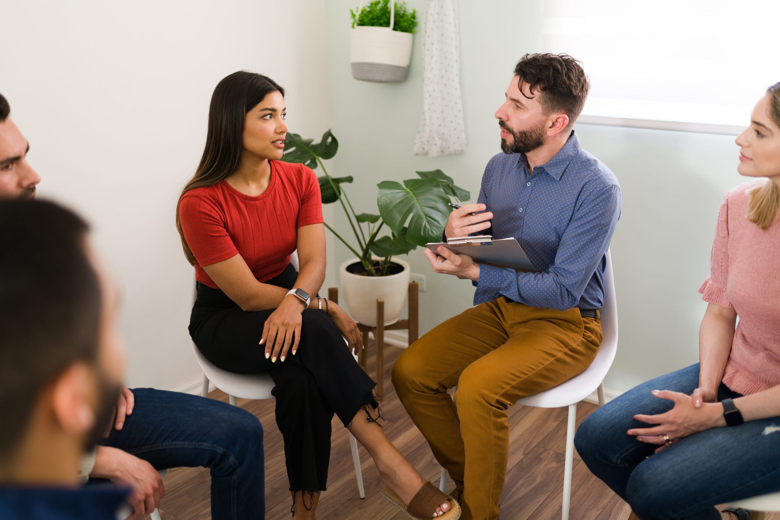 A counselor taking notes during a supportive family conversation
